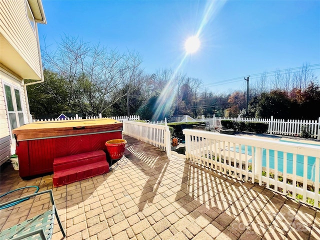 view of patio / terrace featuring a pool, a fenced backyard, and a hot tub