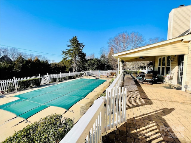 view of swimming pool with a patio, fence, a fenced in pool, and a ceiling fan