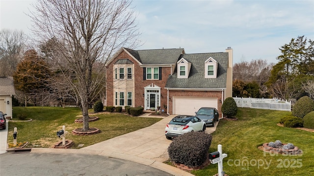 view of front of property with brick siding, a front yard, fence, a garage, and driveway