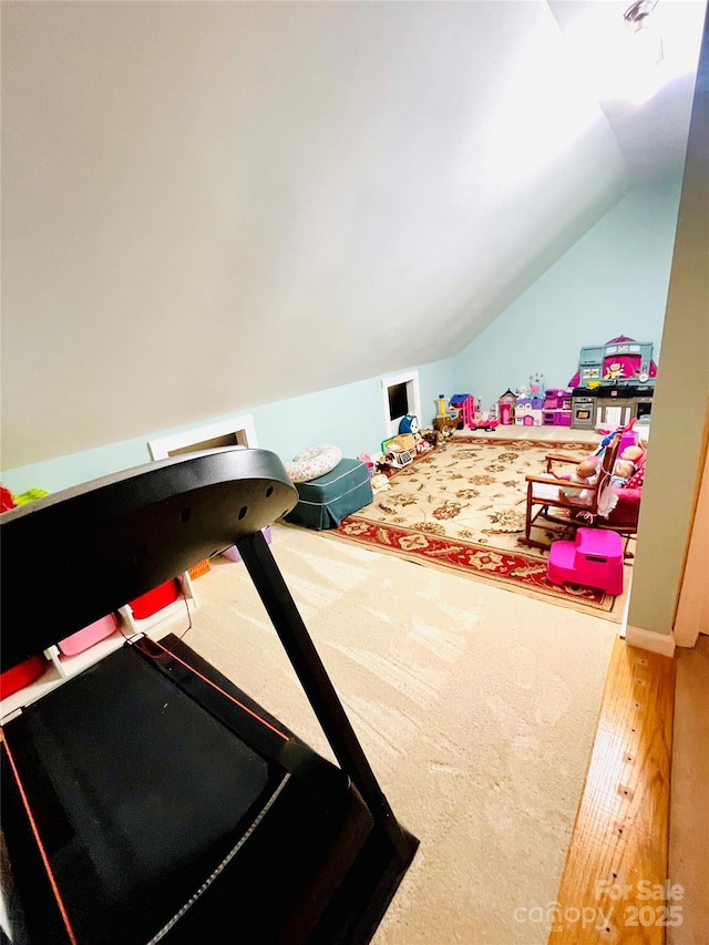 playroom with lofted ceiling and wood finished floors