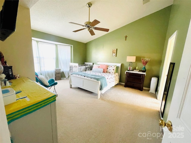 bedroom featuring vaulted ceiling, ceiling fan, a textured ceiling, and light colored carpet