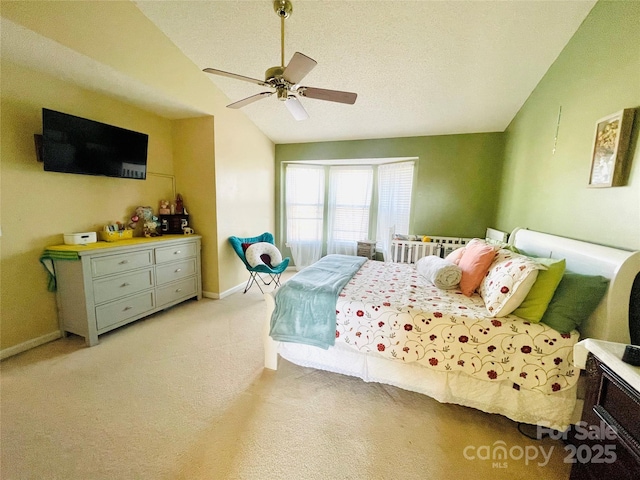 bedroom featuring light carpet, baseboards, a ceiling fan, vaulted ceiling, and a textured ceiling