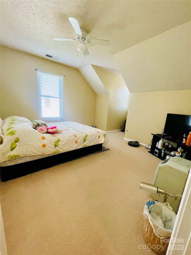 bedroom featuring visible vents, ceiling fan, carpet, vaulted ceiling, and a textured ceiling