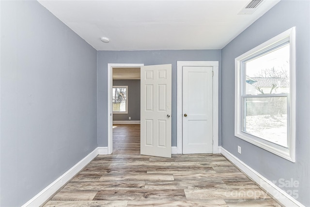 unfurnished bedroom featuring light wood-type flooring, visible vents, and baseboards