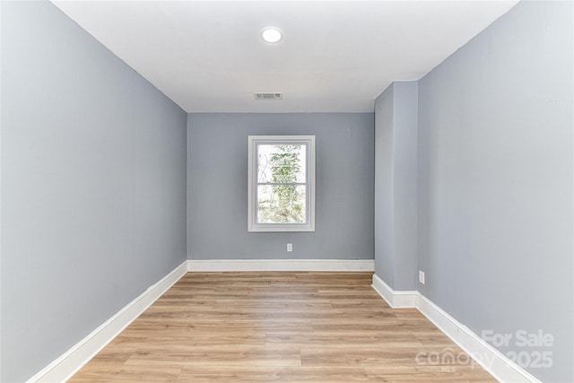 unfurnished room with baseboards, visible vents, and light wood-style floors