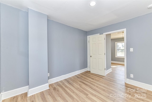 unfurnished room with light wood-style floors and baseboards