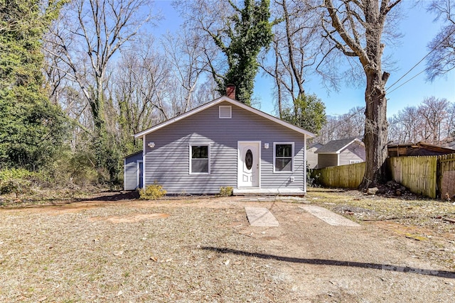 view of front of house with fence and a chimney