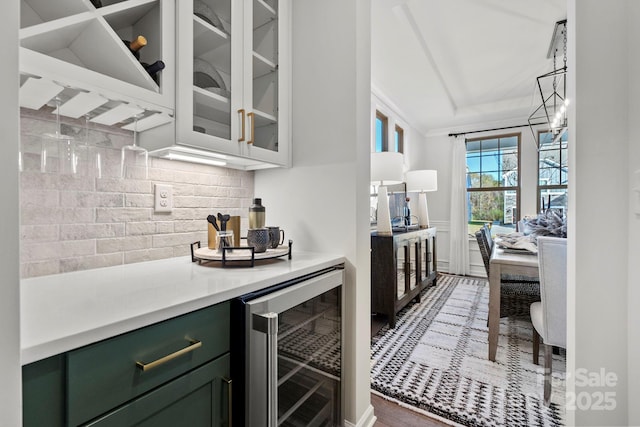 bar with tasteful backsplash, beverage cooler, and wainscoting