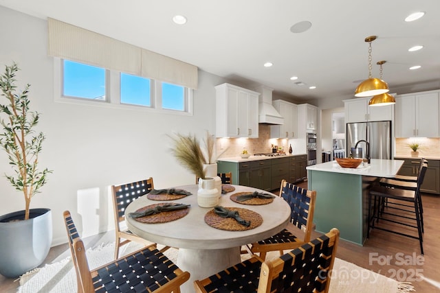 dining room featuring light wood-type flooring and recessed lighting