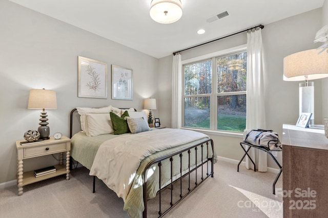 bedroom with light colored carpet, visible vents, and baseboards