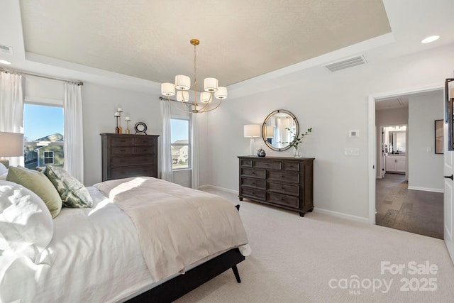 bedroom featuring light carpet, multiple windows, a raised ceiling, and baseboards