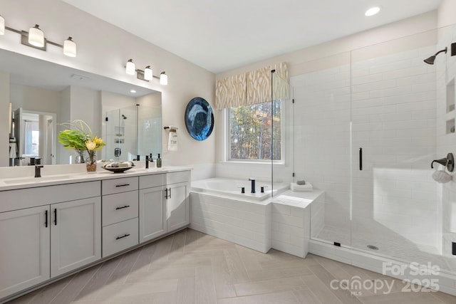 full bathroom with a garden tub, double vanity, a stall shower, and a sink