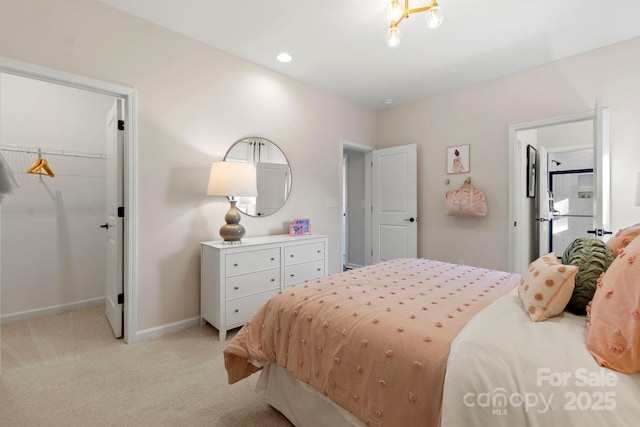 bedroom featuring recessed lighting, light colored carpet, baseboards, a closet, and a walk in closet