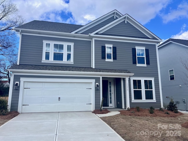 view of front of home with a garage, driveway, and a shingled roof