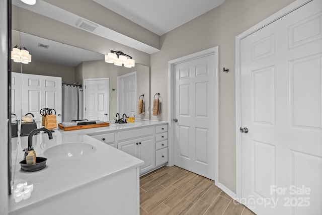 full bathroom with wood finish floors, vanity, and visible vents