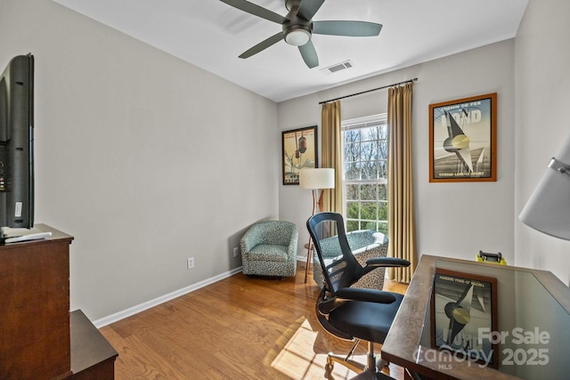 office space with baseboards, ceiling fan, visible vents, and wood finished floors