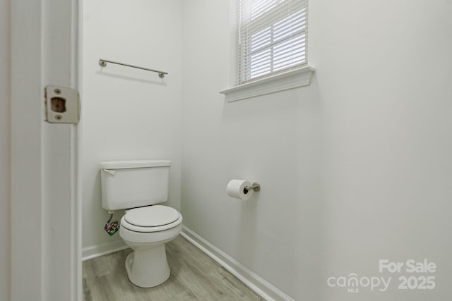 bathroom featuring wood finished floors, toilet, and baseboards