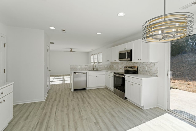 kitchen featuring light countertops, appliances with stainless steel finishes, a sink, and white cabinetry