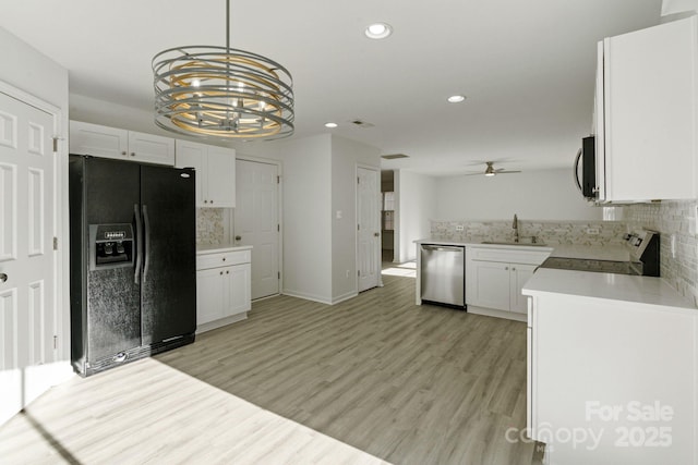 kitchen featuring white cabinetry, light countertops, range, dishwasher, and black refrigerator with ice dispenser