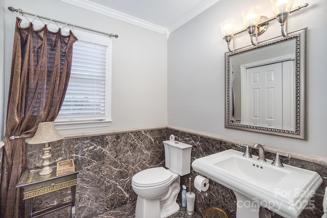 half bathroom with a wainscoted wall, tile walls, toilet, ornamental molding, and a sink