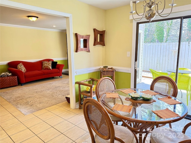 dining space featuring light tile patterned floors, crown molding, and a notable chandelier