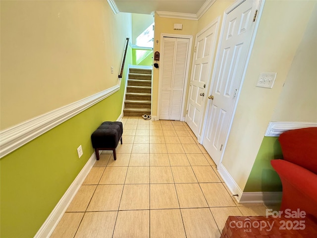 hallway with ornamental molding, stairway, baseboards, and light tile patterned floors