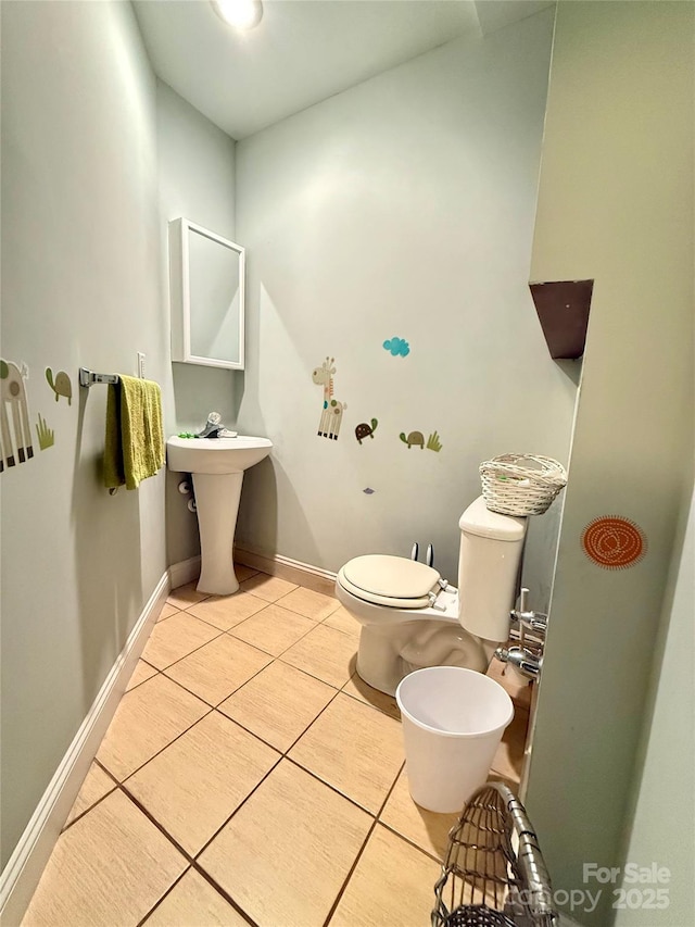 bathroom featuring tile patterned floors, toilet, and baseboards