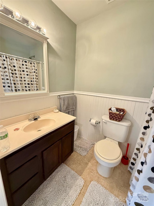 full bath featuring a wainscoted wall, vanity, toilet, and tile patterned floors