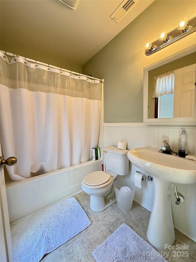 bathroom with toilet, shower / bath combination with curtain, visible vents, and tile patterned floors