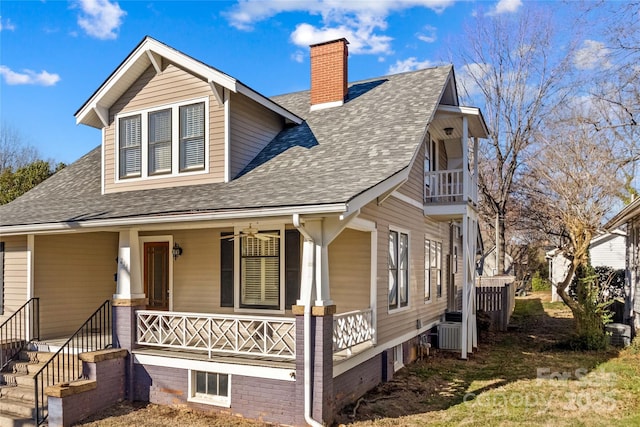 view of front of house featuring a porch, roof with shingles, a chimney, and a balcony