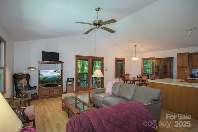 living room with light wood-type flooring, ceiling fan, and vaulted ceiling