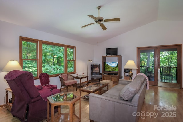 living room featuring lofted ceiling, light wood finished floors, and plenty of natural light