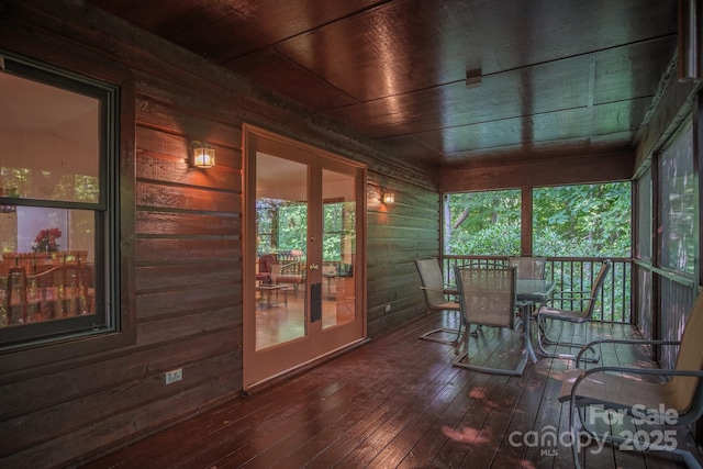 sunroom / solarium featuring wood ceiling, plenty of natural light, and french doors