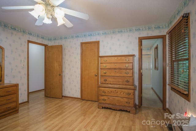 bedroom featuring light wood-type flooring and wallpapered walls