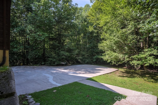 view of sport court with a yard