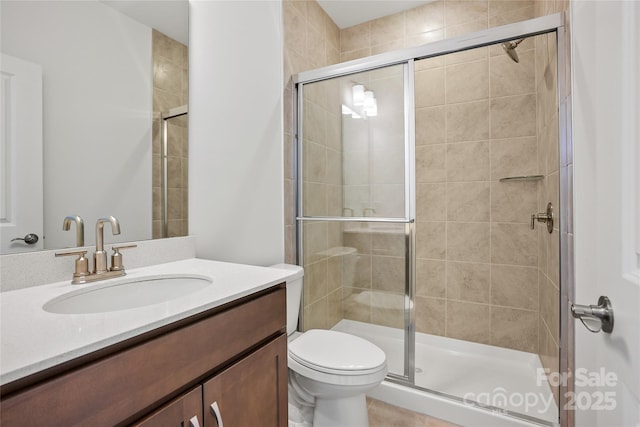 full bathroom with a stall shower, vanity, and toilet