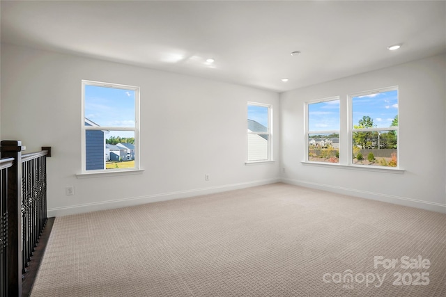 interior space featuring baseboards, a healthy amount of sunlight, recessed lighting, and light colored carpet