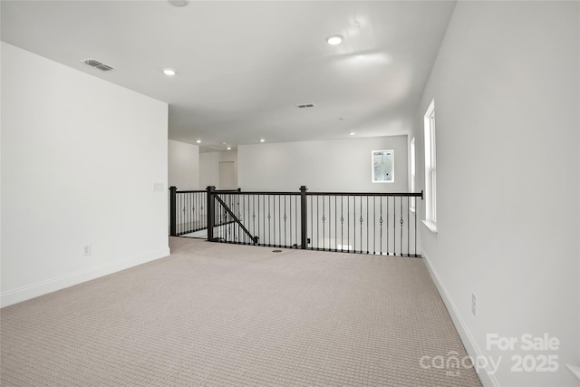 empty room featuring light carpet, recessed lighting, visible vents, and baseboards