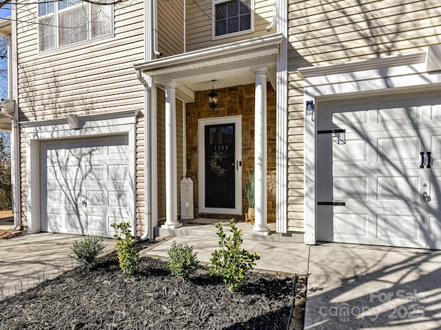 property entrance with a garage and concrete driveway