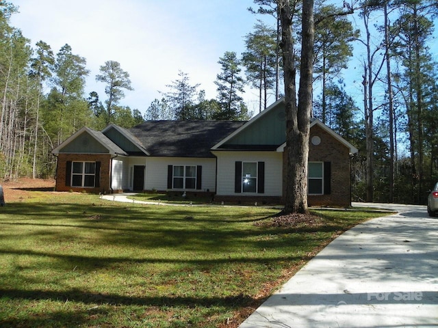 view of front of house featuring brick siding and a front lawn