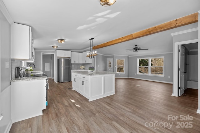 kitchen featuring white cabinets, freestanding refrigerator, decorative backsplash, electric range oven, and crown molding