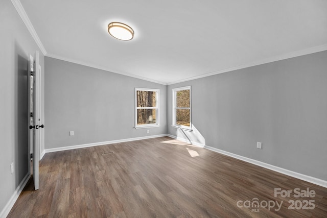 unfurnished room with dark wood-style flooring, crown molding, and baseboards