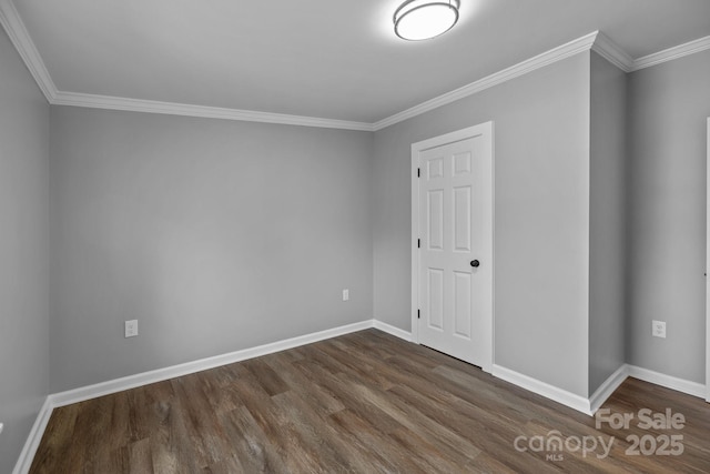 unfurnished room with baseboards, dark wood finished floors, and ornamental molding