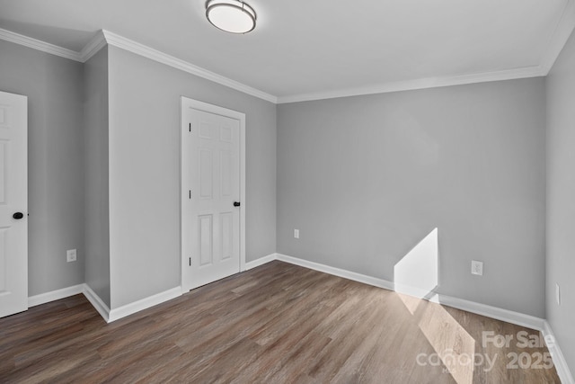 spare room with baseboards, wood finished floors, and ornamental molding