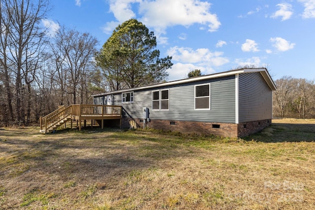 back of property with crawl space, a lawn, stairway, and a wooden deck