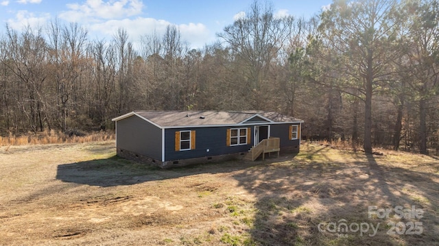 manufactured / mobile home featuring crawl space and a wooded view