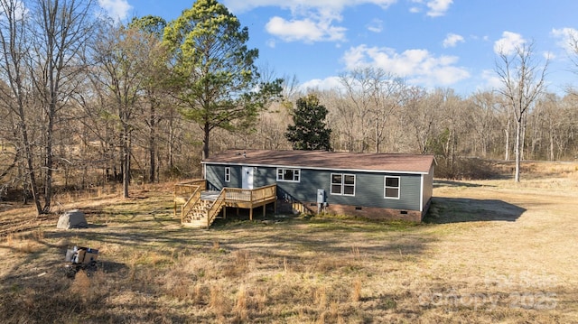 manufactured / mobile home with stairway, crawl space, a deck, and a front lawn