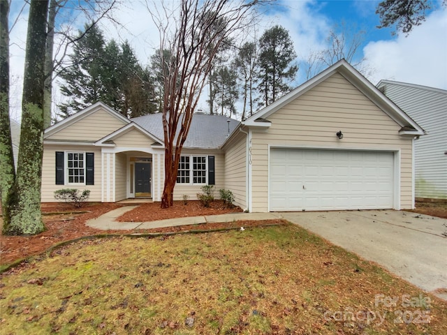 ranch-style home with a garage, concrete driveway, and a front yard