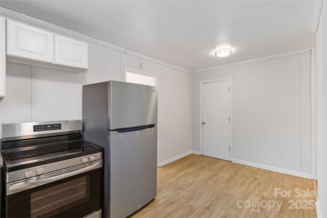 kitchen featuring appliances with stainless steel finishes, light wood-type flooring, and white cabinets