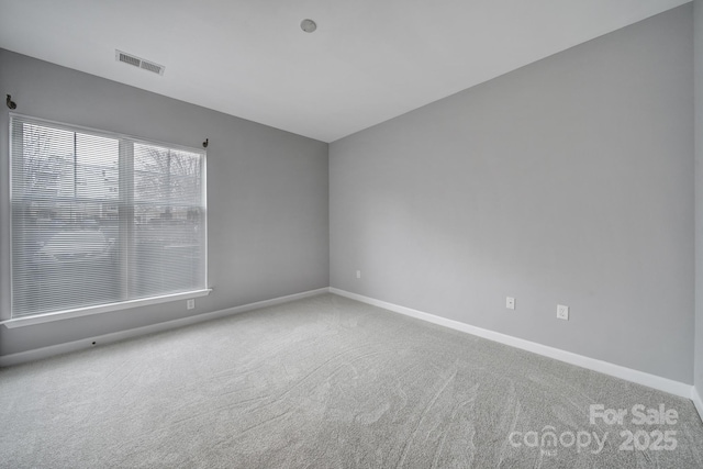 spare room with baseboards, visible vents, and carpet flooring